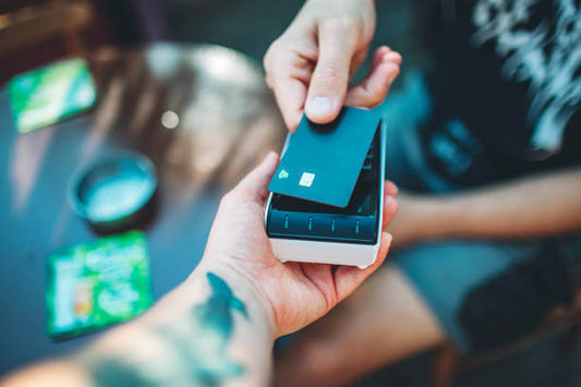 Tattoo artist making payment for tattoo equipment with a credit card reader